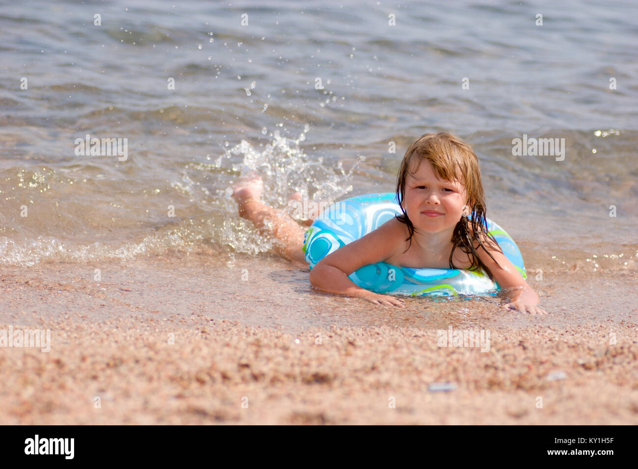 Kind am Strand Liegen im warmen Meer transparentes Wasser auf sie mit