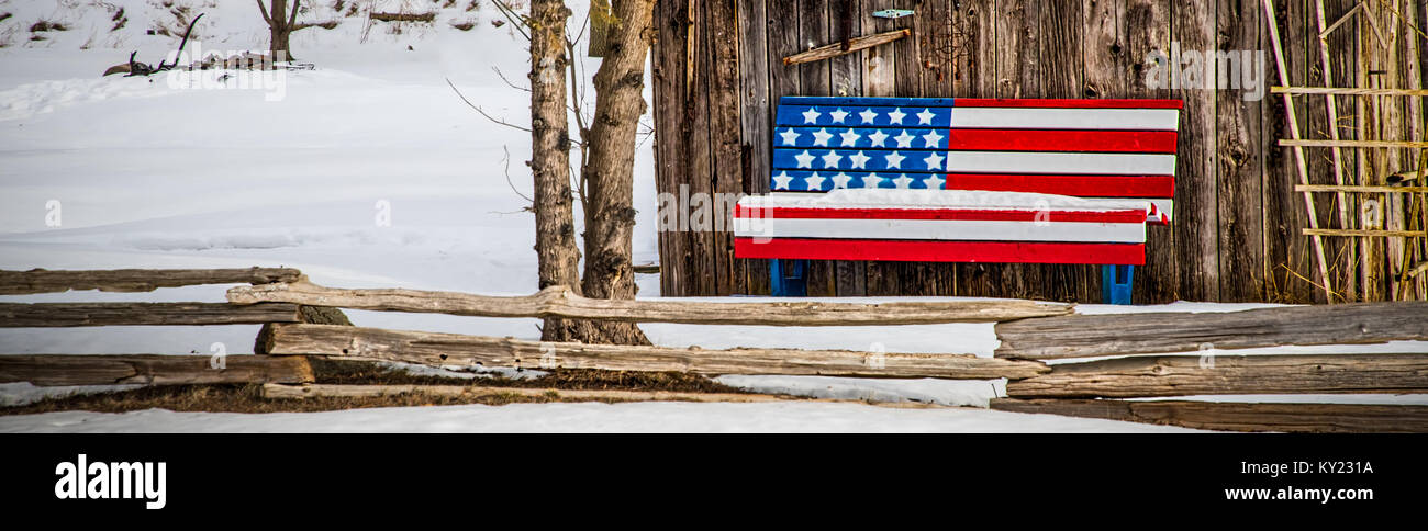 Eine patriotische Bank sitzt vor einer Hütte im Wisconsin Landschaft. Stockfoto