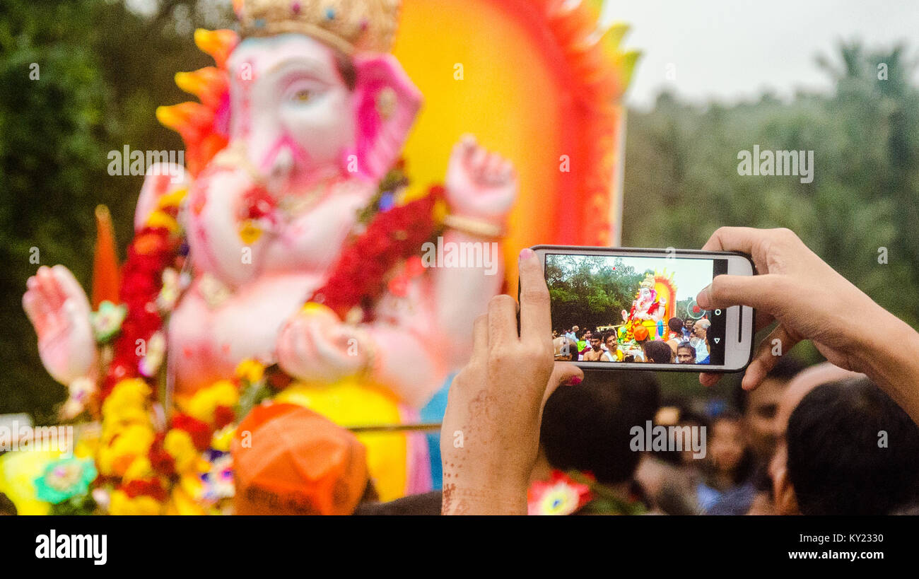 Fokus auf den Vordergrund auf einem Mobiltelefon Aufnahme Ganesh visarjan (Immersion) Prozession. Stockfoto