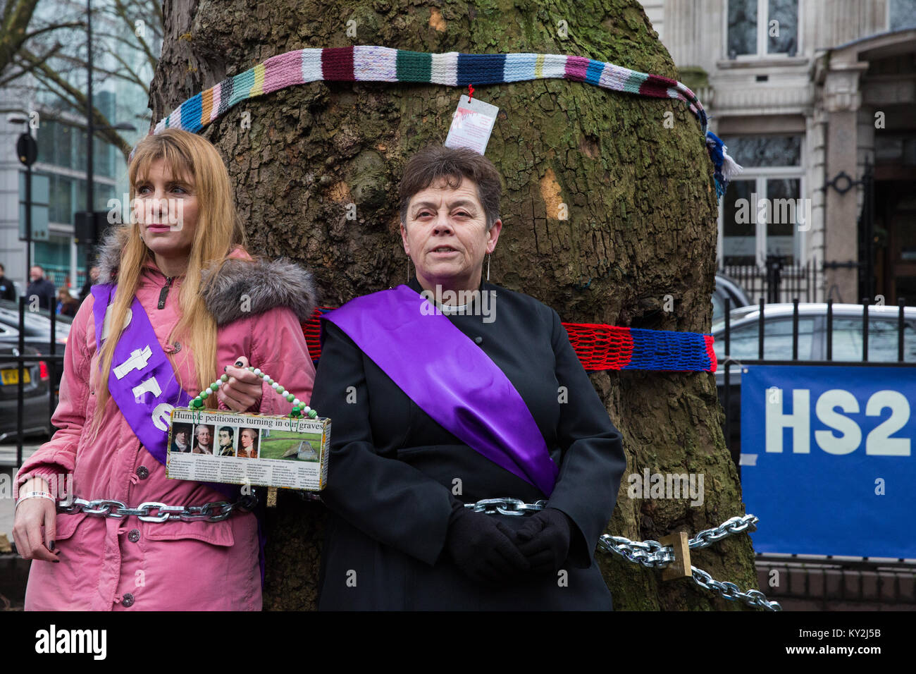 London, Großbritannien. Januar 2018. Anne Stevens, der Vikar der St. Pancras Kirche, wird an einen Baum mit Jo Hurford außerhalb Euston Station als Teil einer Kampagne von Anwohnern aus Protest gegen den geplanten Abschlag von reifen London Flugzeug, Red Oak, Common Lime, Gemeinsame Weißbeam- und Wilddienstbäume in den Euston Square Gardens, um im Rahmen der Vorbereitungen für die HS2-Bahnstrecke temporäre Baustellen und einen verdrängten Taxistand freizumachen. Kredit: Mark Kerrison/Alamy Live Nachrichten Stockfoto