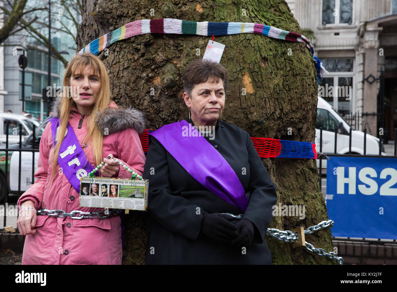 London, Großbritannien. Januar 2018. Anne Stevens, der Vikar der St. Pancras Kirche, wird an einen Baum mit Jo Hurford außerhalb Euston Station als Teil einer Kampagne von Anwohnern aus Protest gegen den geplanten Abschlag von reifen London Flugzeug, Red Oak, Common Lime, Gemeinsame Weißbeam- und Wilddienstbäume in den Euston Square Gardens, um im Rahmen der Vorbereitungen für die HS2-Bahnstrecke temporäre Baustellen und einen verdrängten Taxistand freizumachen. Stockfoto