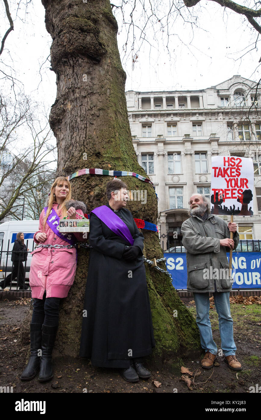 London, Großbritannien. Januar 2018. Anne Stevens, der Vikar der St. Pancras Kirche, wird an einen Baum mit Jo Hurford außerhalb Euston Station als Teil einer Kampagne von Anwohnern aus Protest gegen den geplanten Abschlag von reifen London Flugzeug, Red Oak, Common Lime, Gemeinsame Weißbeam- und Wilddienstbäume in den Euston Square Gardens, um im Rahmen der Vorbereitungen für die HS2-Bahnstrecke temporäre Baustellen und einen verdrängten Taxistand freizumachen. Stockfoto