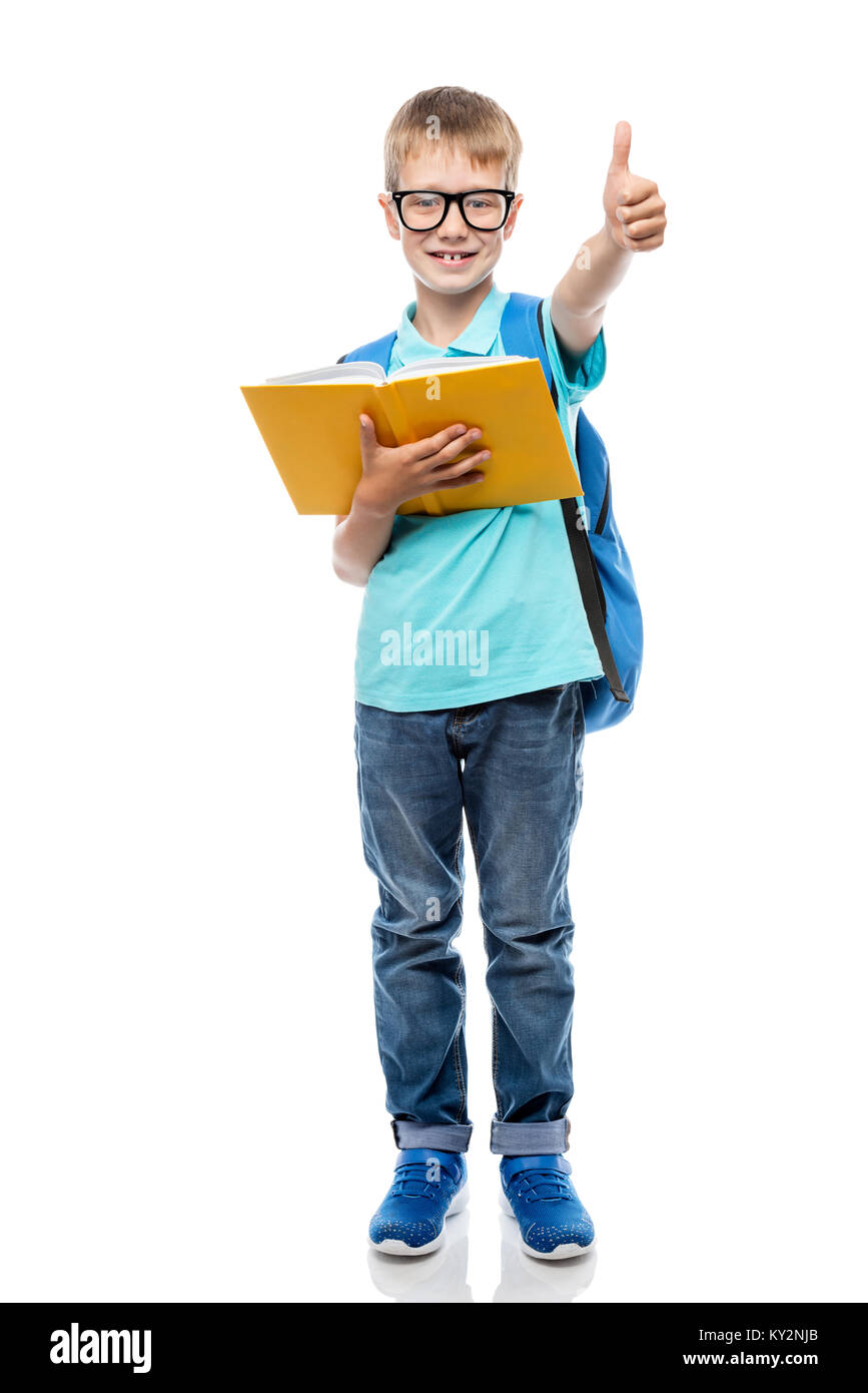 Smart Schulkind mit Brille mit einem Buch auf einem weißen Hintergrund in voller Länge Stockfoto