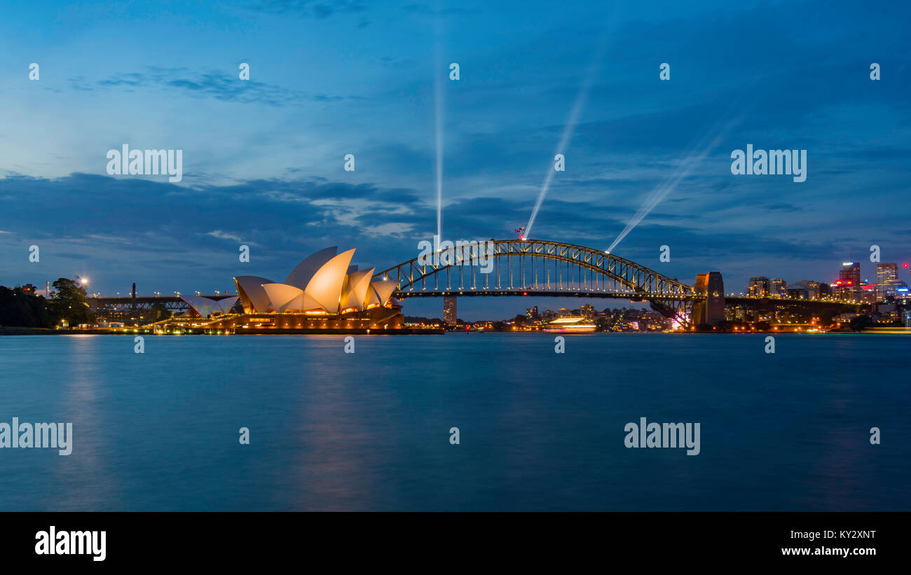 Die Sydney Harbour Bridge und Opera House beleuchtet mit speziellen Lampen in der Vorbereitung für Silvester nur auf Dämmerung von den Royal Botanic Gardens Stockfoto