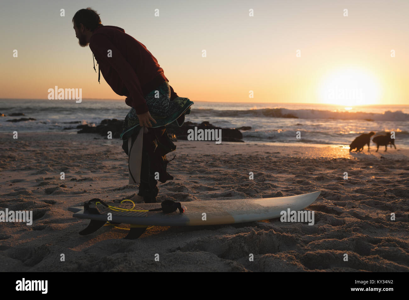 Surfboard entfernen Neoprenanzug am Strand Stockfoto