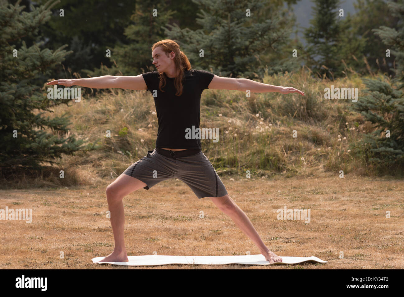 Passen mann Durchführung stretching Übung auf offenen Boden Stockfoto