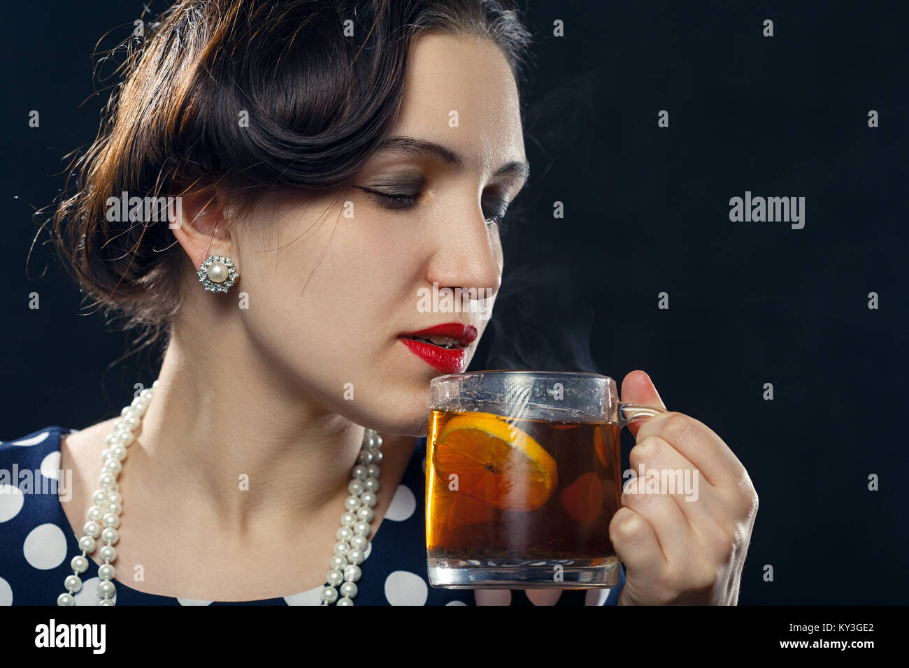 Schöne pinup Frau mit einer Tasse Tee auf schwarzem Hintergrund Stockfoto