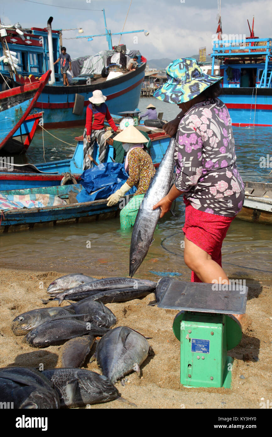 Frauen, Boote, Fische und Waage am Strand von Nha Trang Stockfoto