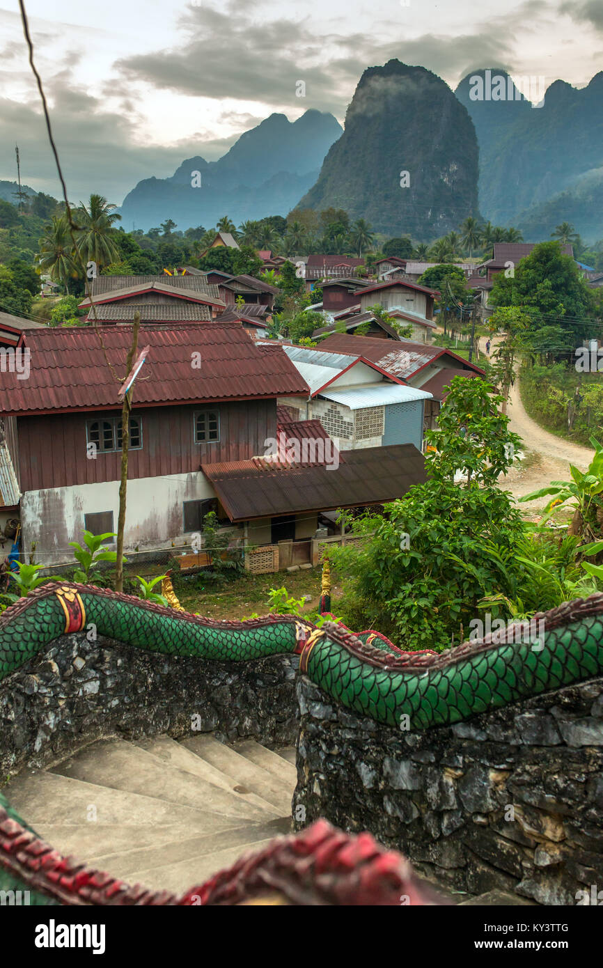 Die traditionellen laotischen Dorf mit Tempel Treppen und Berg Hintergrund in der Nähe von Vang Vieng, Laos. Stockfoto