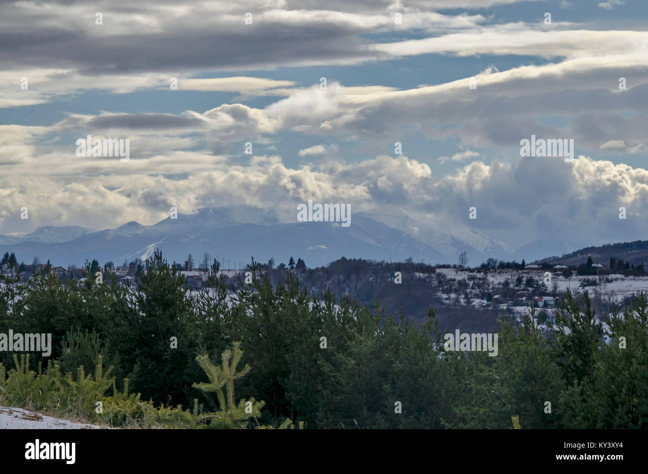 Majestätischen Blick auf bewölkter Himmel, im Winter die Berge, verschneite Lichtung, Wohnviertel, Nadel- und Laubwald von Plana Berg in Richtung Rila-gebirge Stockfoto