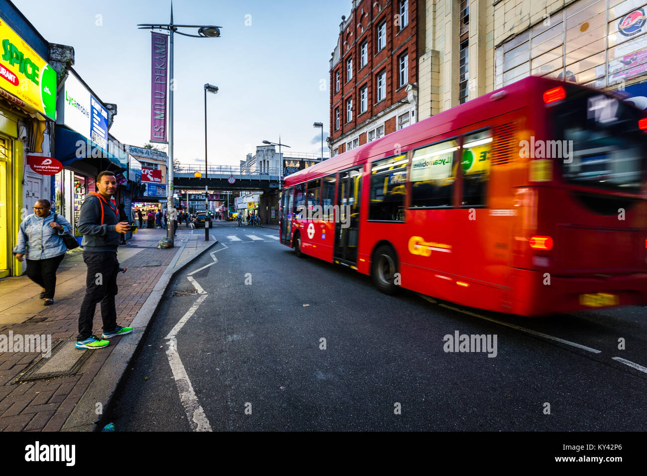 Straßenszene in Peckham, London, mit roten Bus Stockfoto
