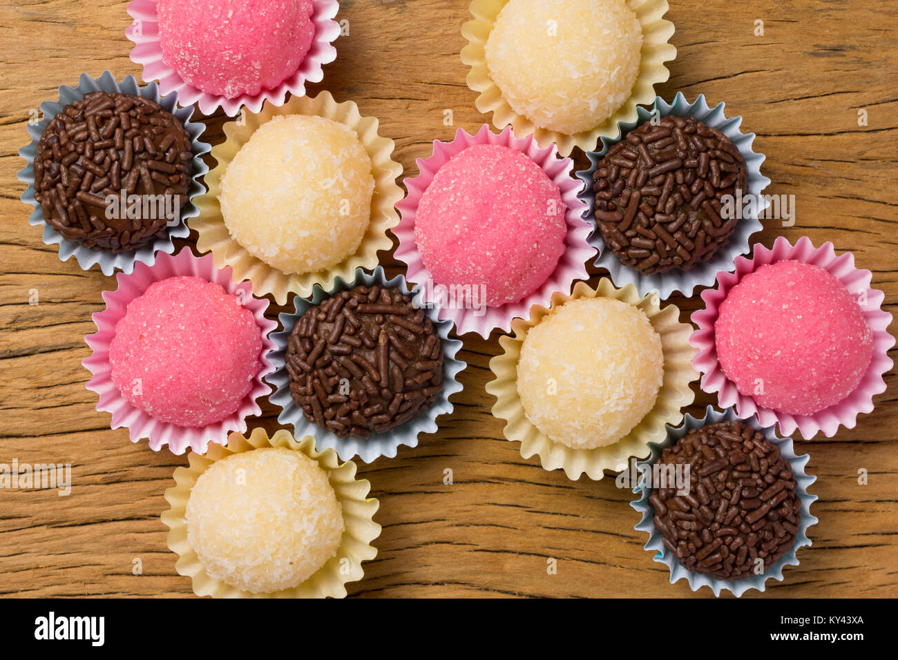 Brasilianische Spezialitäten: Brigadeiro, Beijinho und Bicho de Pe. Kindergeburtstag. Overhead von candy Ball auf rustikalen Holztisch. Stockfoto