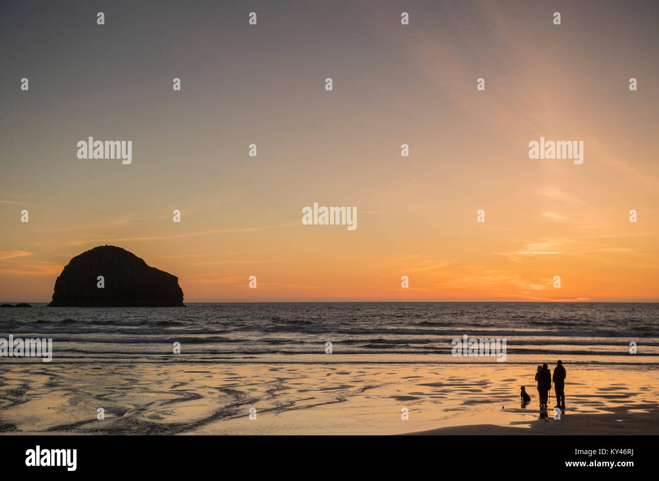 Die Leute am Strand zum Sonnenuntergang bei Trebarwith Strand in Cornwall, England, UK Watch Stockfoto