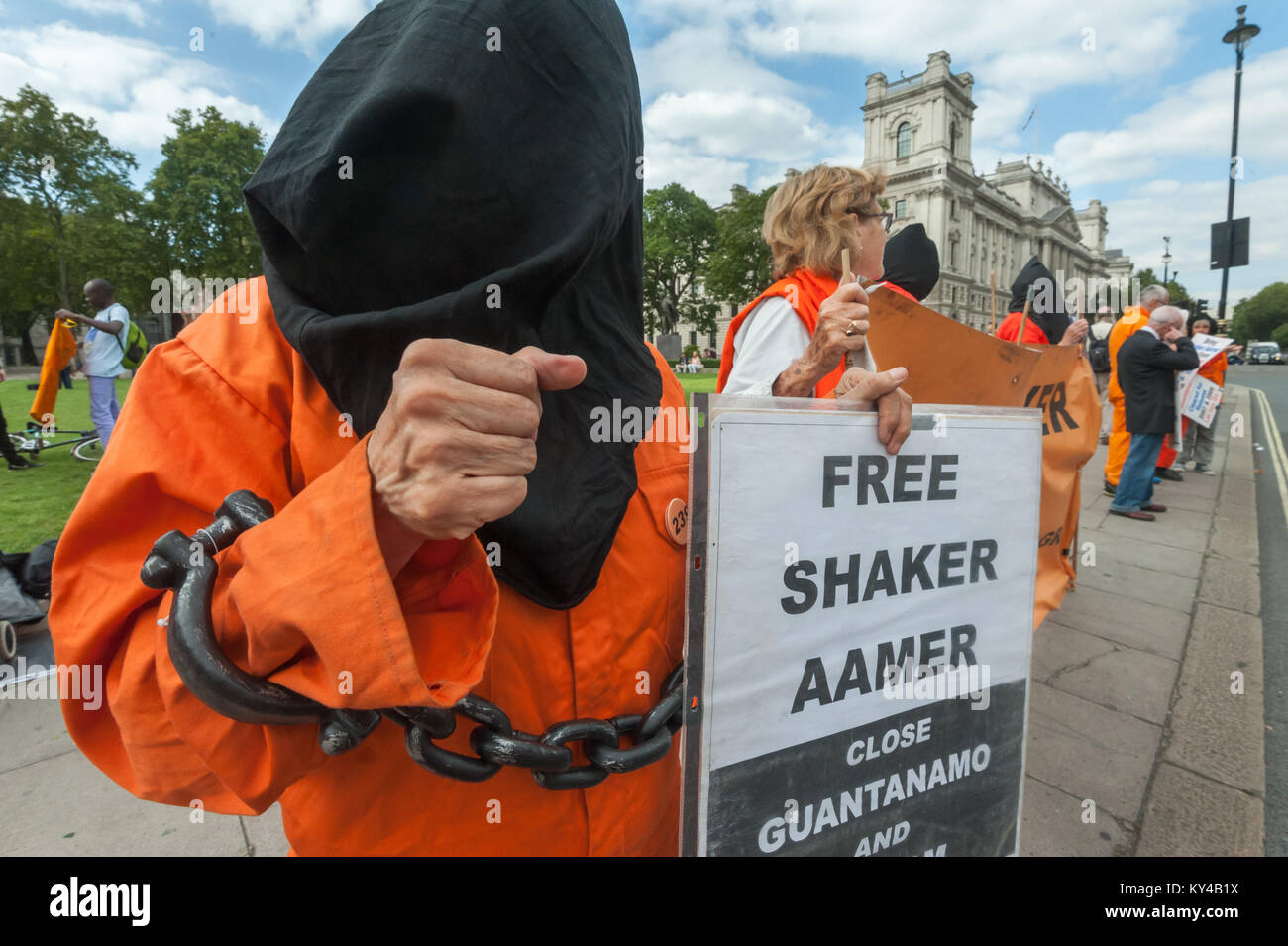 Ein Mitkämpfer in schwarz Haube, organd Overall und Ketten wirft eine Faust in Defiance bei der wöchentlichen Mahnwache für Londoner Shaker Aamer, fordert von der britischen Regierung für seine sofortige Freilassung zu drücken. Stockfoto