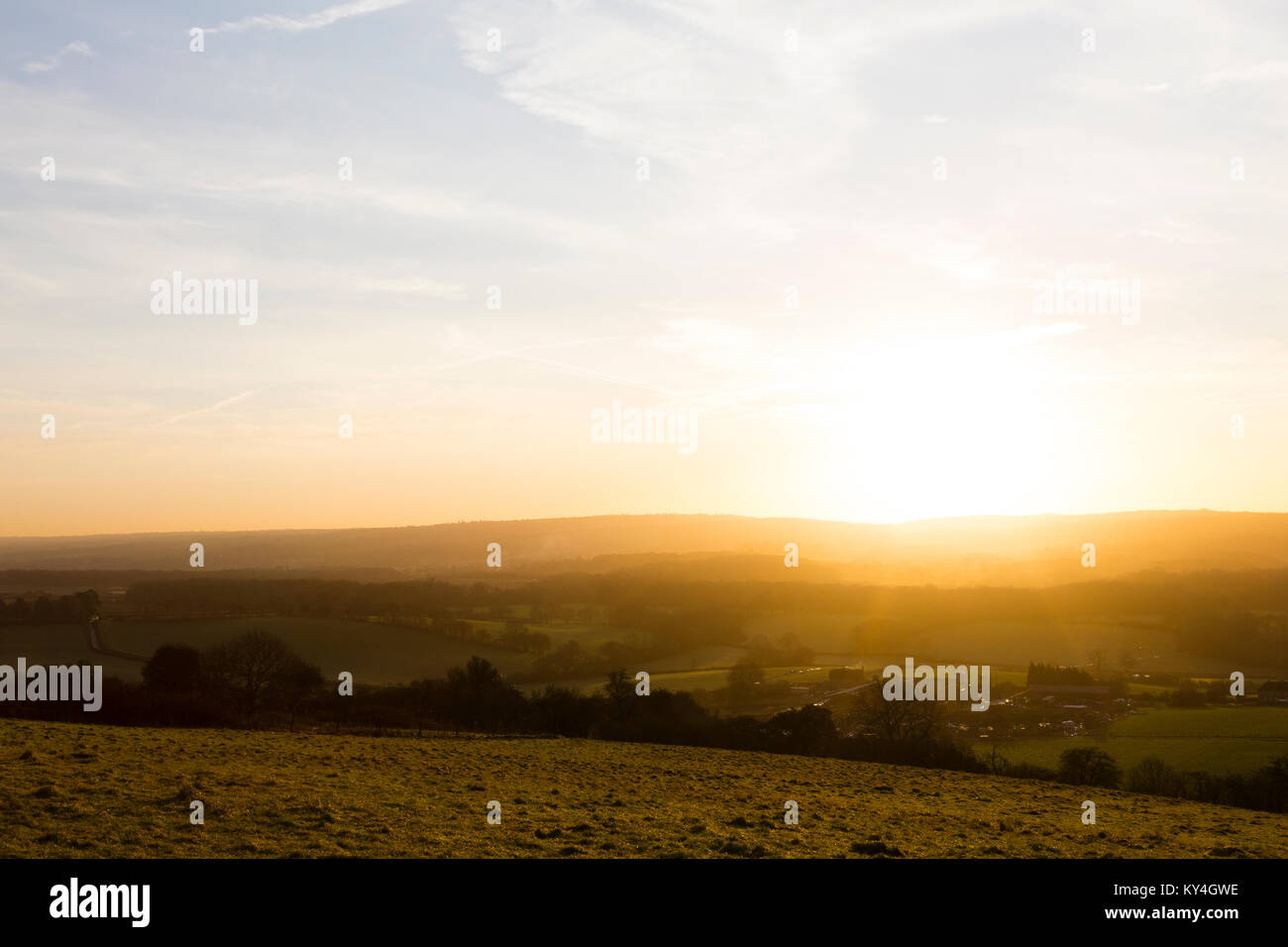 Titsey, UK. Die Sonne beleuchtet die Felder und Bauernhöfe von North Surrey gegen einen hellblauen Himmel. Stockfoto