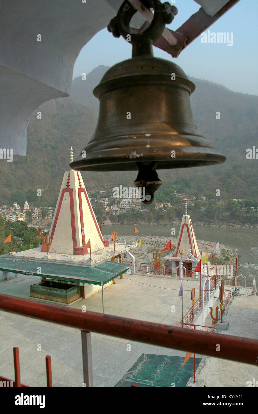 Tempel am Ufer des Flusses Ganga mit Messing Glocke im Vordergrund, Rishikesh, Uttarakhand, Indien, Asien Stockfoto