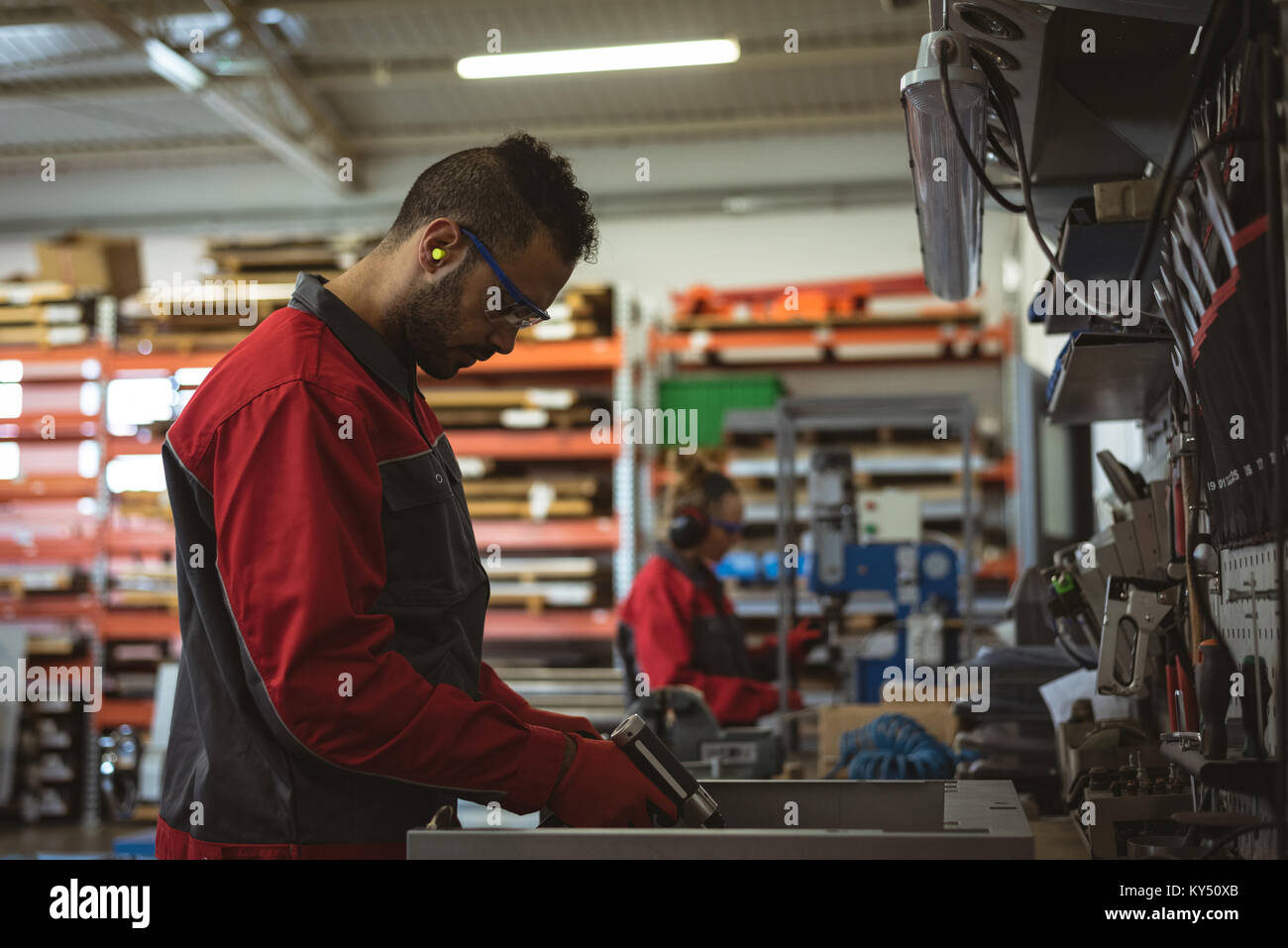 Männliche Arbeiter Reparatur einer Maschine mit Werkzeug Stockfoto