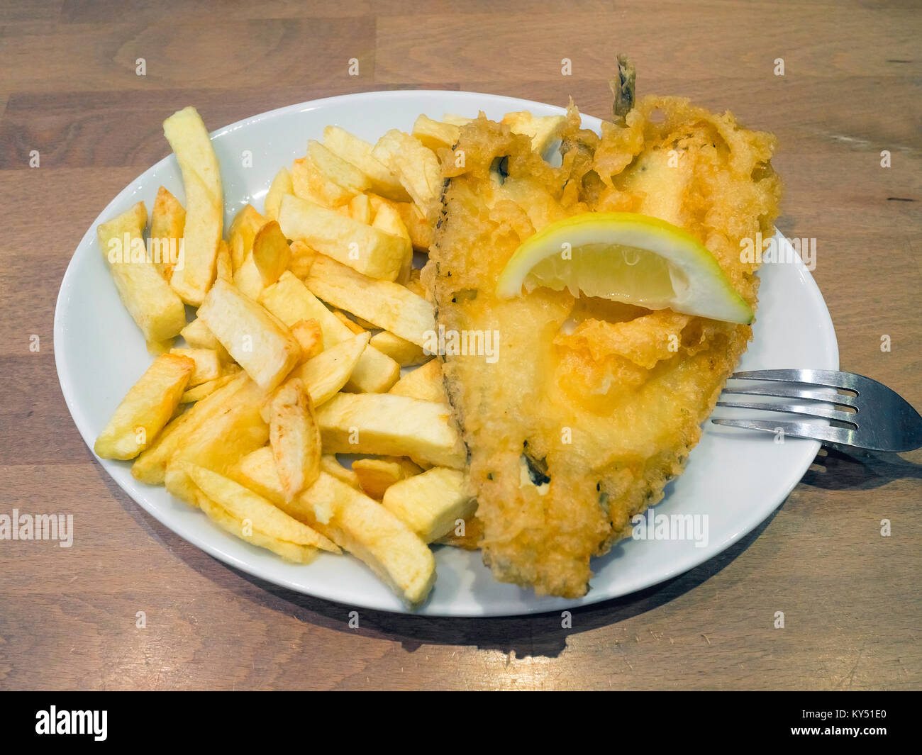 Eine Umhüllung von Scholle und Chips mit schönen Teig und einer Scheibe Zitrone bereit zum Essen in ein Restaurant Stockfoto