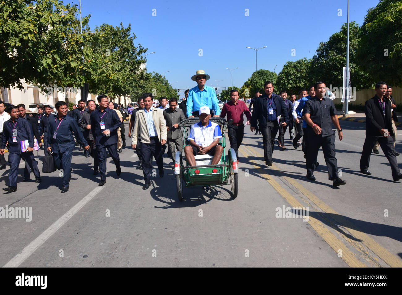 Phnom Penh, Kambodscha. 13 Jan, 2018. Techo kambodschanischen Premierminister Samdech Hun Sen (C Hinten) fährt ein Cyclo in Phnom Penh, Kambodscha, Jan. 13, 2018. Hun Sen am Samstag veranstaltete ein Mittagessen zum ersten Mal für 308 cyclo Betreiber und ein Cyclo-Stiftung ins Leben gerufen. Cyclo ist ein dreirädriges Fahrrad - selbstfahrende Rikscha, dass der Treiber den Sitzstangen auf Hoch über dem Hinterrad, und die Passagiere in einem Schalensitz mit Schlingen zwischen den beiden vorderen Rädern. Credit: Sovannara/Xinhua/Alamy leben Nachrichten Stockfoto