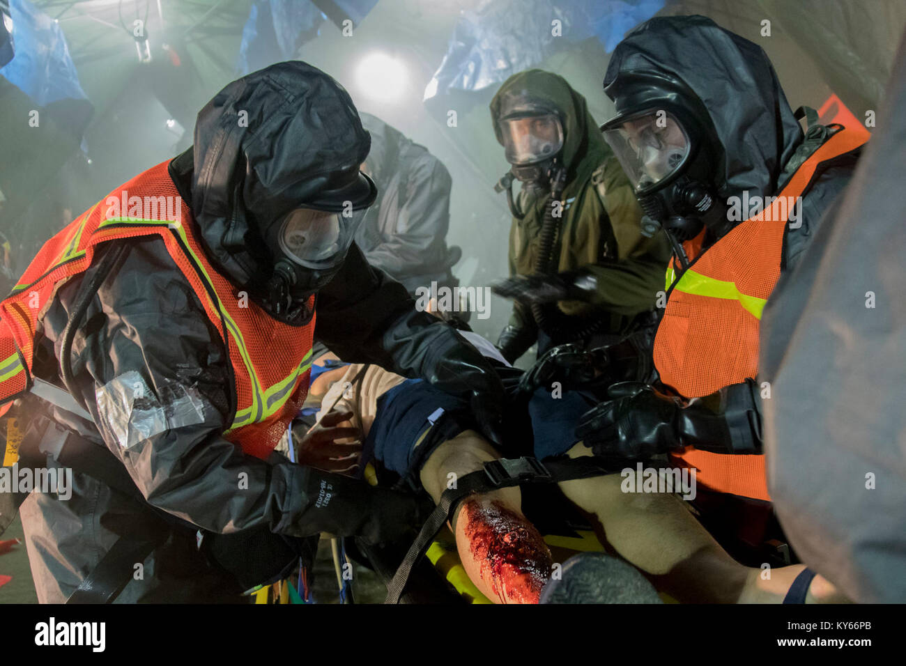 Us-Armee Soldat bewertet simulierten Unfall während einer Messe Unfallversicherung Dekontamination Übung auf dem Homestead-Miami Speedway, in Miami, Florida, Jan. 9, 2018. Dies ist die dritte in einer Reihe gemeinsamer Übungen zwischen Active Duty, Schutz, und Reservearmee Einheiten und Kommunen über den Vereinigten Staaten. Diese jte konzentrierte sich auf die Dekontamination und Transport von Verletzten in einer simulierten Masse chemische Angriffe. (DoD Stockfoto