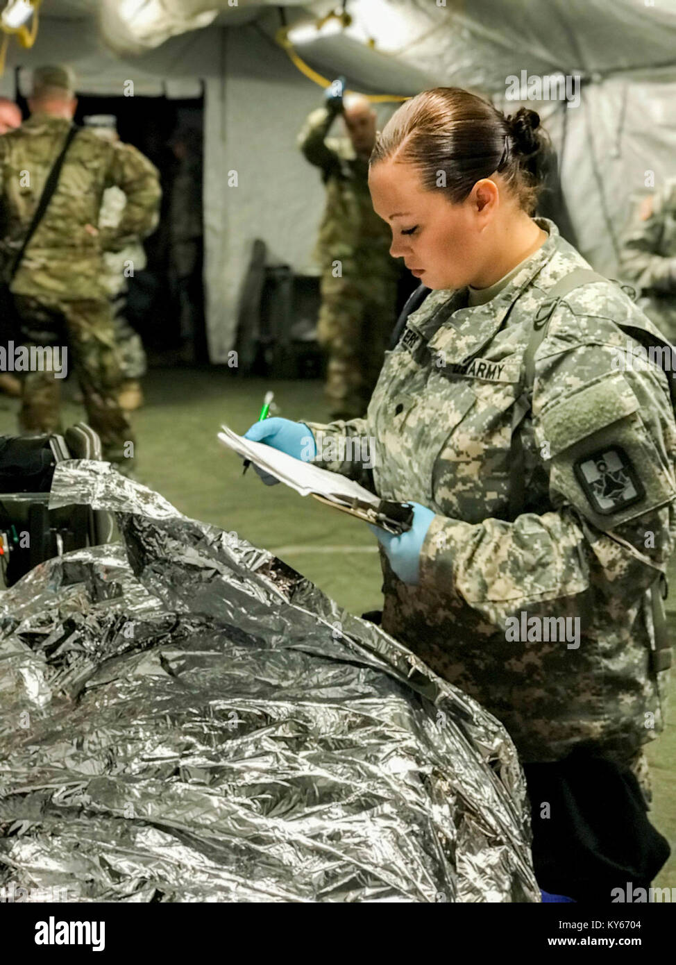 Us-Armee Soldat exanime simulierten Unfall während einer Messe Unfallversicherung Dekontamination Übung auf dem Homestead-Miami Speedway, in Miami, Florida, Jan. 9, 2018. Dies ist die dritte in einer Reihe gemeinsamer Übungen zwischen Active Duty, Schutz, und Reservearmee Einheiten und Kommunen über den Vereinigten Staaten. Diese jte konzentrierte sich auf die Dekontamination und Transport von Verletzten in einer simulierten Masse chemische Angriffe. (DoD Stockfoto