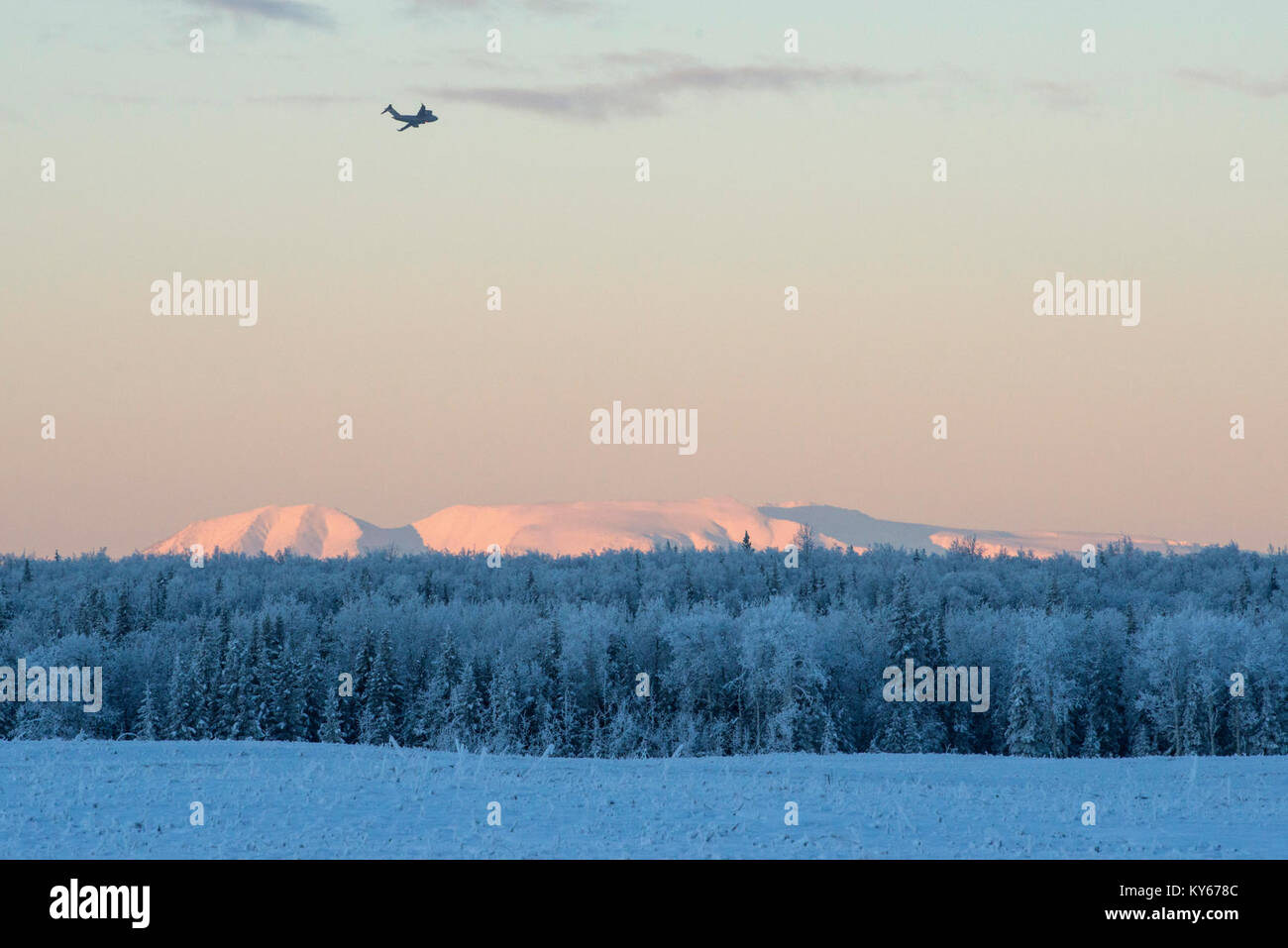 Ein US Air Force C-17 Globemaster III, dem 517Th Airlift Squadron zugeordnet, fliegen in Richtung Mount Susitna, nachdem es Fallschirmjäger in die 4 Infantry Brigade Combat Team (Airborne), 25 Infanterie Division, U.S. Army Alaska, über malemute Drop Zone zugeordnet, Joint Base Elmendorf-Richardson, Alaska, Jan. 9, 2018. Die C-17 Globemaster III ist in der Lage, rasche strategische Bereitstellung von Truppen und alle Arten von Fracht zu den wichtigsten Stützpunkte oder direkt an uns Basen im Einsatzgebiet. (U.S. Air Force Stockfoto