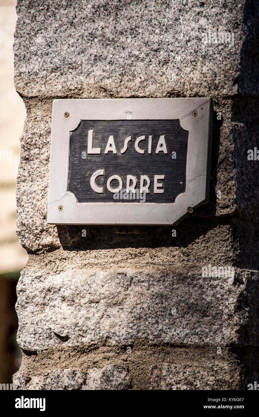 Steinmauer mit der sprichwörtlichen Aufschrift in Corse Sprache, Lascia Corre (lassen Sie es gehen), häufig gesagt, eine Einladung, die Dinge nicht zu ernst zu nehmen Stockfoto