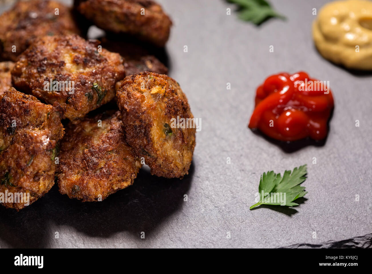 Schiefer Tafel mit hausgemachten frikadellen aus Schweinefleisch, Rindfleisch und Gemüse mit Tomatensauce und Senf hergestellt Stockfoto