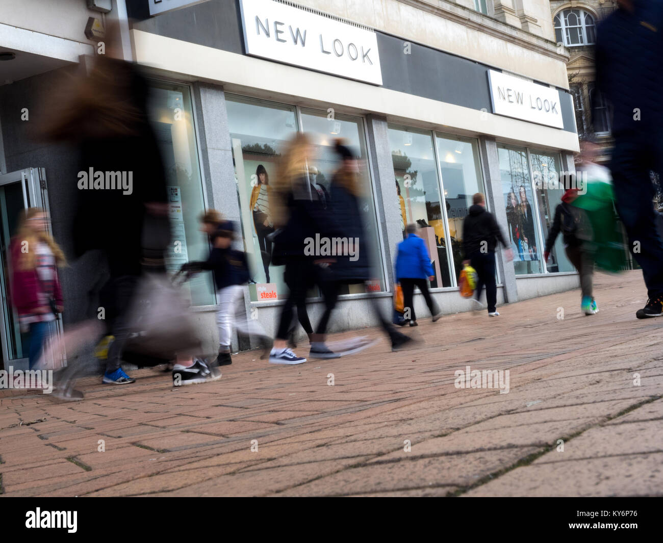 Mehrere Menschen zu Fuß vorbei an einem neuen Store suchen, in der Bewegung verschwommen Stockfoto