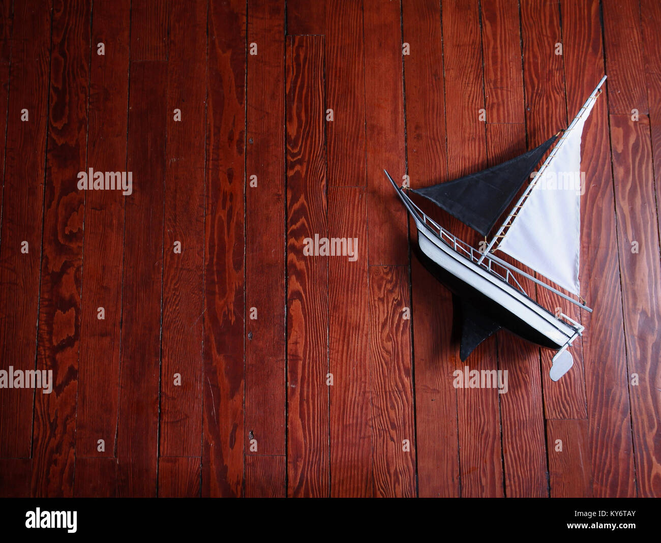 Ein altes Modell Segelschiff aus Holz auf einem Hartholzboden mit dramatischen Beleuchtung abgeschwächt mit einem Vintage Retro instagram Filterwirkung app oder Aktion Stockfoto
