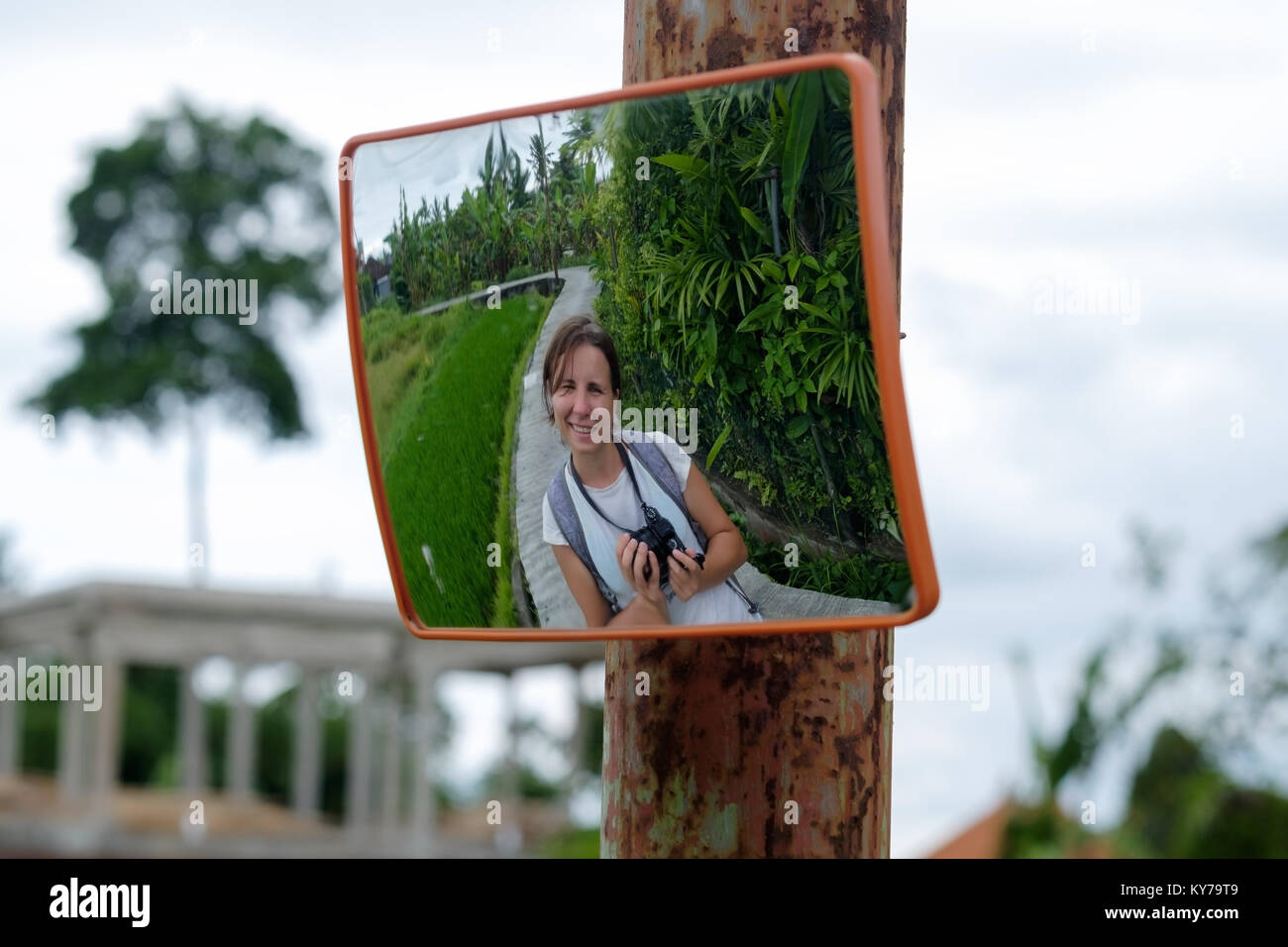 Unterwegs in Bali Reis Terrasse. Kaukasische Frau Lächeln in der Straße Spiegel Stockfoto