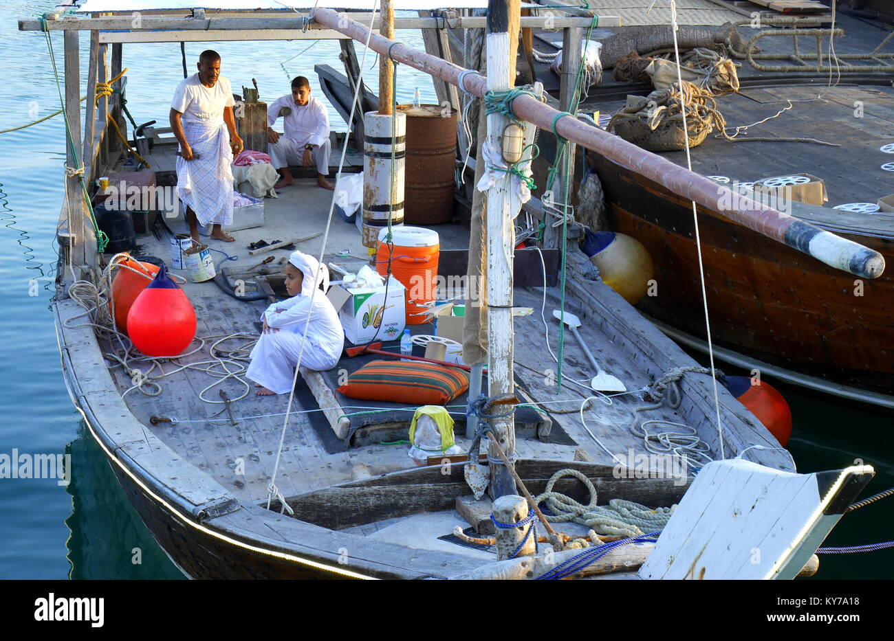 Bahraini Junge, trägt ein dishdasha, sitzen auf dem Deck einer Dhow, während das Meer Festival, Manama, Königreich Bahrain Stockfoto