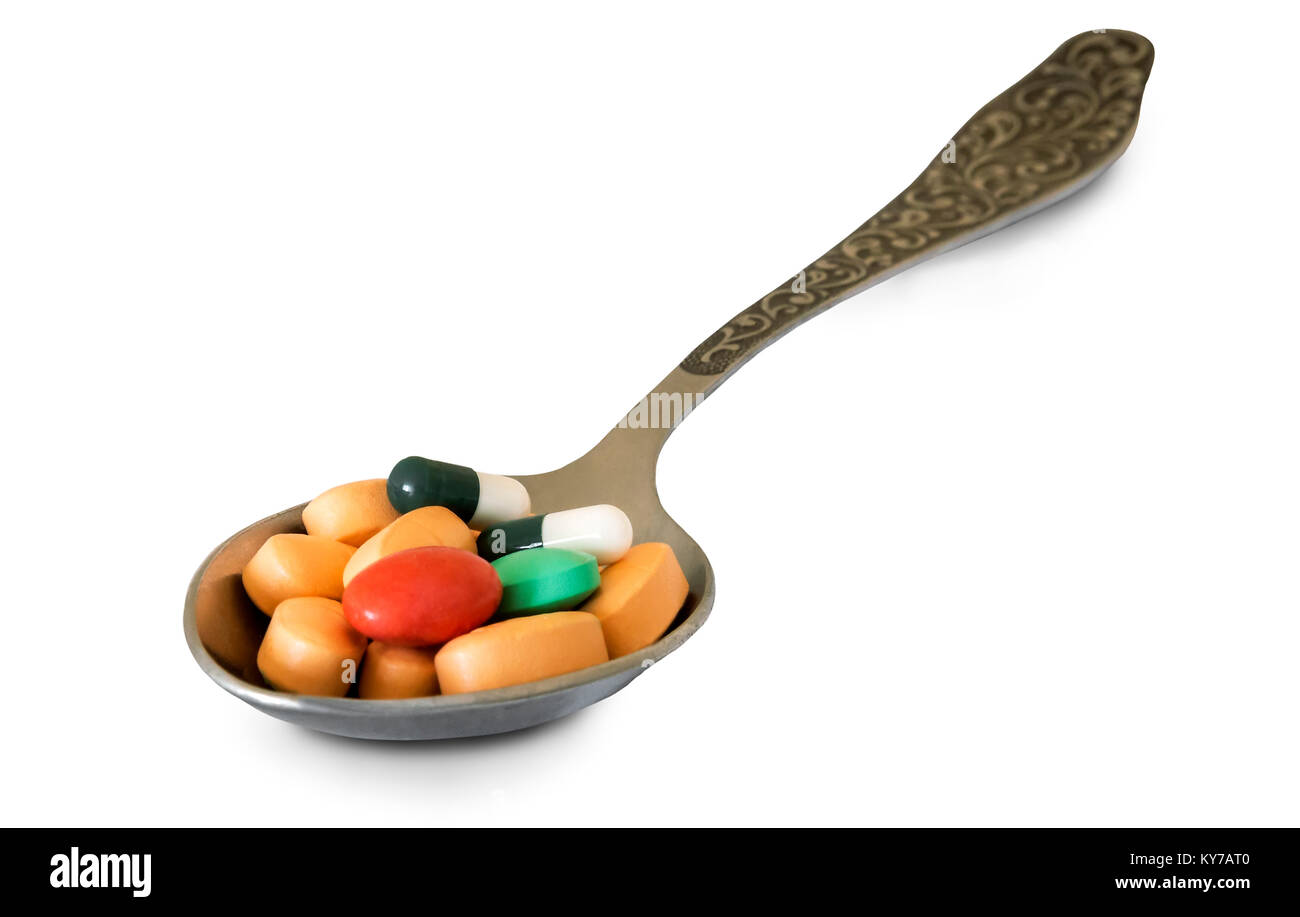 In einem metalllöffel verschiedene Medikamente in Form von Tabletten. Auf einem weißen Hintergrund dargestellt. Stockfoto