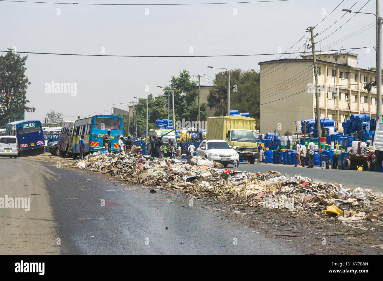Einen großen Haufen von plastik Müll und anderen Abfällen sitzt in der Mitte der Straße als Menschen und Fahrzeuge Vergangenheit gehen, Nairobi, Kenia, Ostafrika Stockfoto