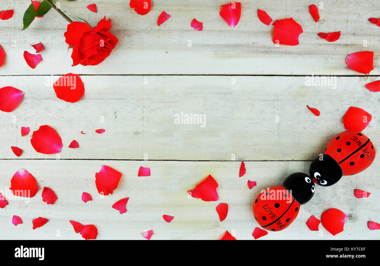 Konzept mit Maske, Wort Liebe mit Rosenblättern geschrieben und eine rote Rose Stockfoto