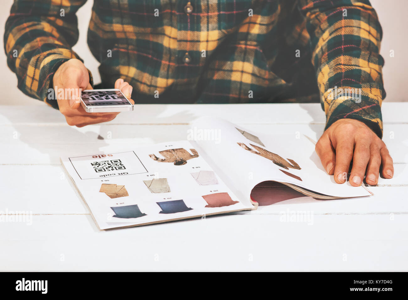 Mann Shopping Scannen QR-Code Werbung mit Smartphone auf Kleidung Katalog moderne Technologie und Fashion Retail Konzept Stockfoto