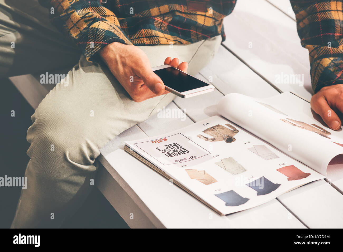 Mann Shopping Scannen QR-Code Werbung mit Smartphone auf Kleidung Katalog moderne Technologie und Fashion Retail Konzept Stockfoto