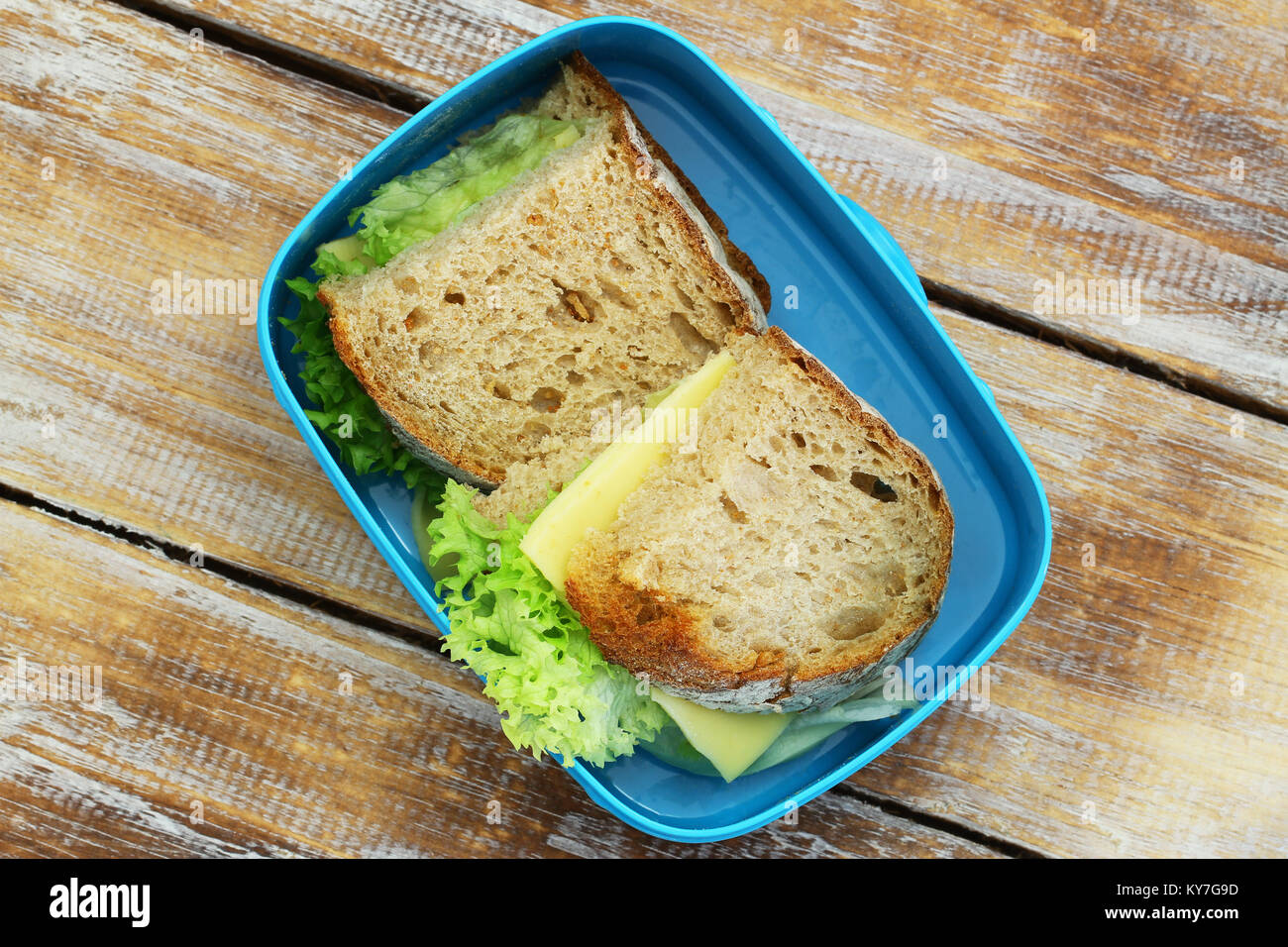 Rustikales Brot Sandwiches mit Käse und Salat in Lunch Box auf Holzmöbeln im Landhausstil Oberfläche Stockfoto