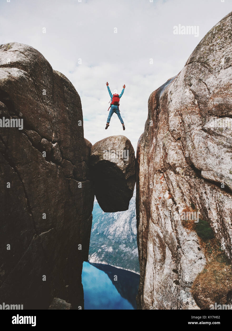 Mann über Kjeragbolten Reisen in Norwegen Kjerag bergen extreme Ferien Abenteuer touristische glücklich Emotionen erfolg konzept springen Stockfoto