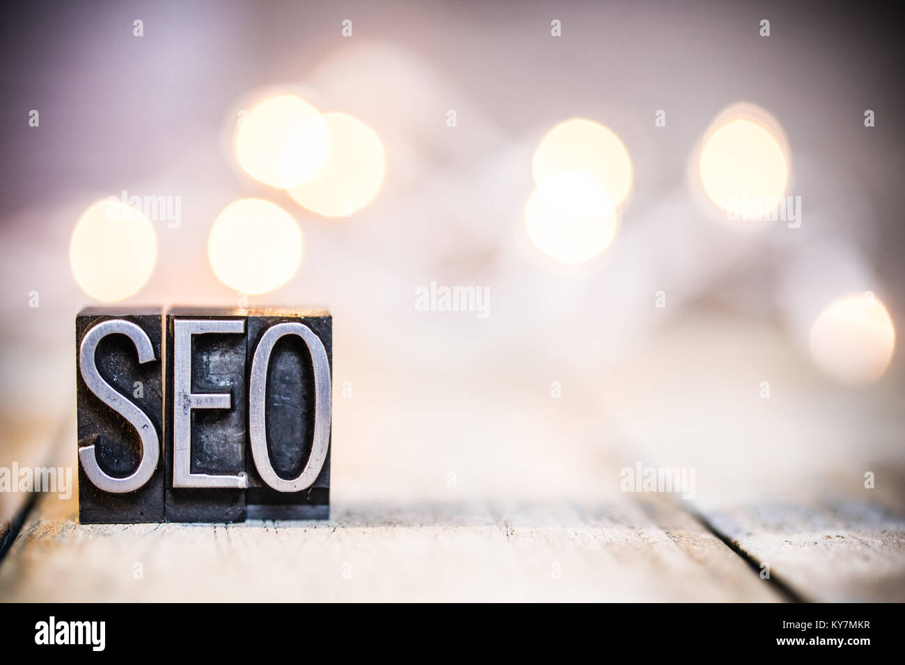 Das Wort SEO im Vintage metall Buchdruck Art auf einem bokeh Licht und Holz- Hintergrund geschrieben. Stockfoto