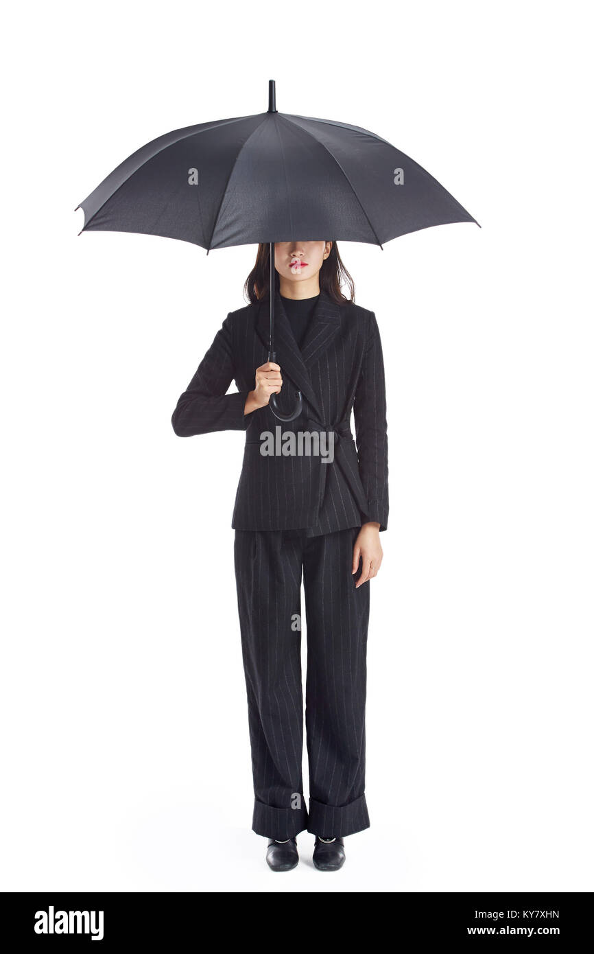 Studio Aufnahme einer jungen asiatischen Business Frau mit einem schwarzen Regenschirm, auf weißem Hintergrund. Stockfoto
