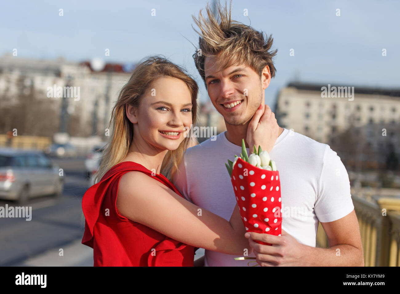 Glückliches junges Paar mit Blumenstrauß Lächeln zusammen im Freien, Liebe auf den ersten Blick Stockfoto