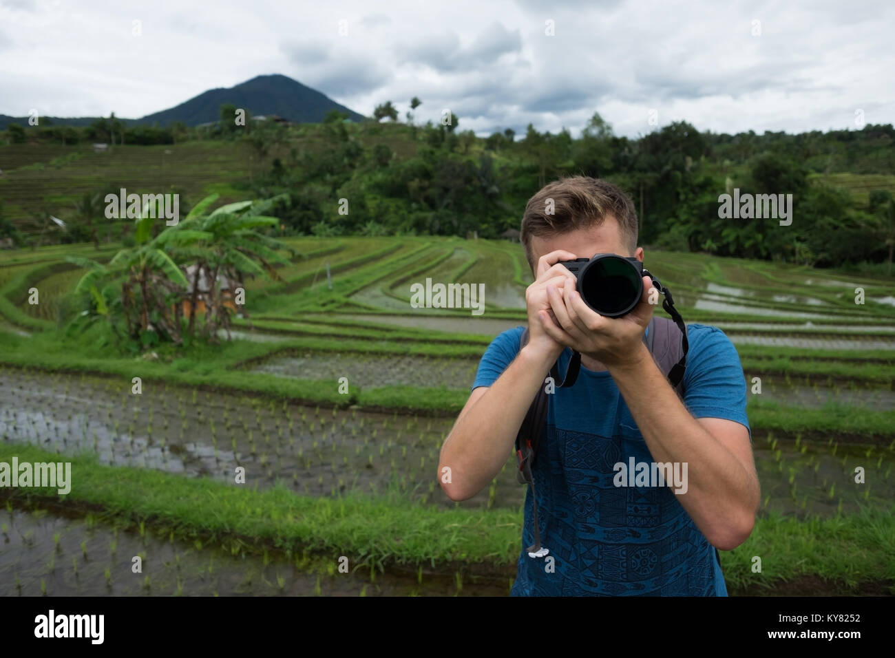 Junger Mann Reisender, Foto und entspannende Außenpool am Reis Felder auf Bali Indonesien angebaut. Stockfoto