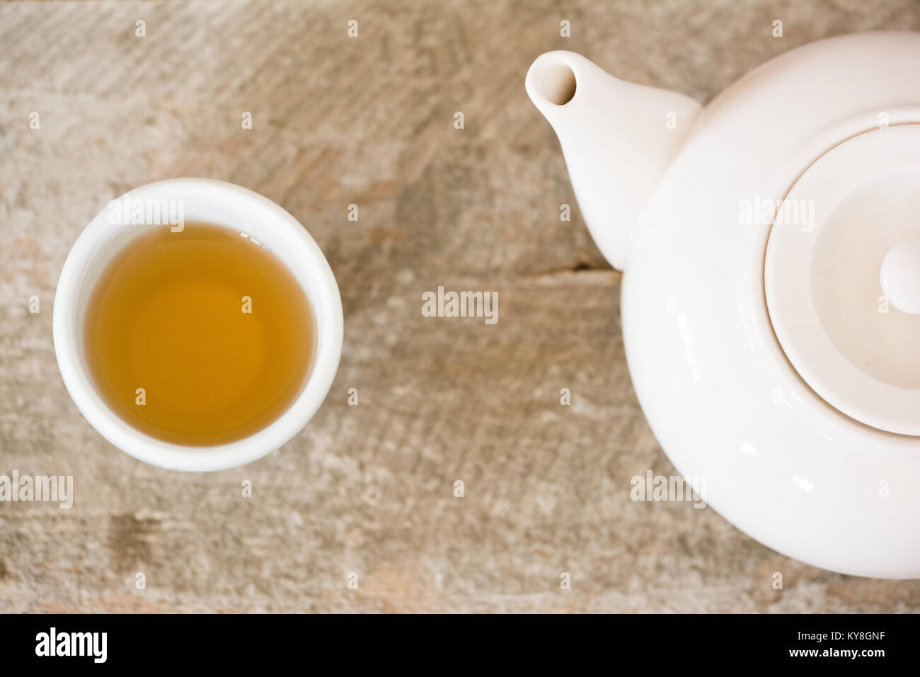 Weiß Teetasse und Teekanne mit greentea und rustikalen Holzmöbeln Hintergrund Stockfoto