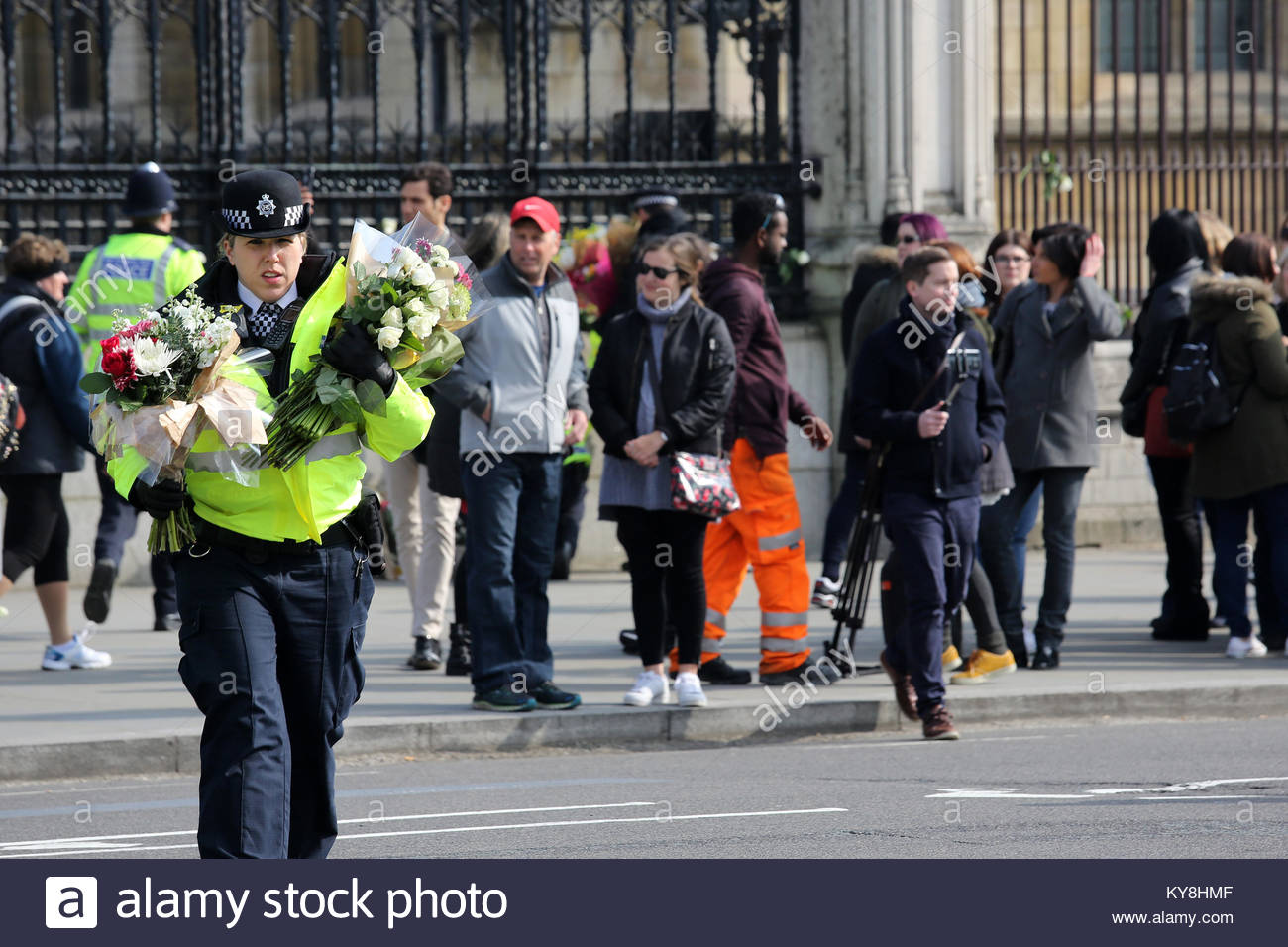 Ein Polizei Polizist trägt Blumensträuße über die Straße am Westminster nach der London Bridge. Credit: reallifephotos/Alamy Stockfoto