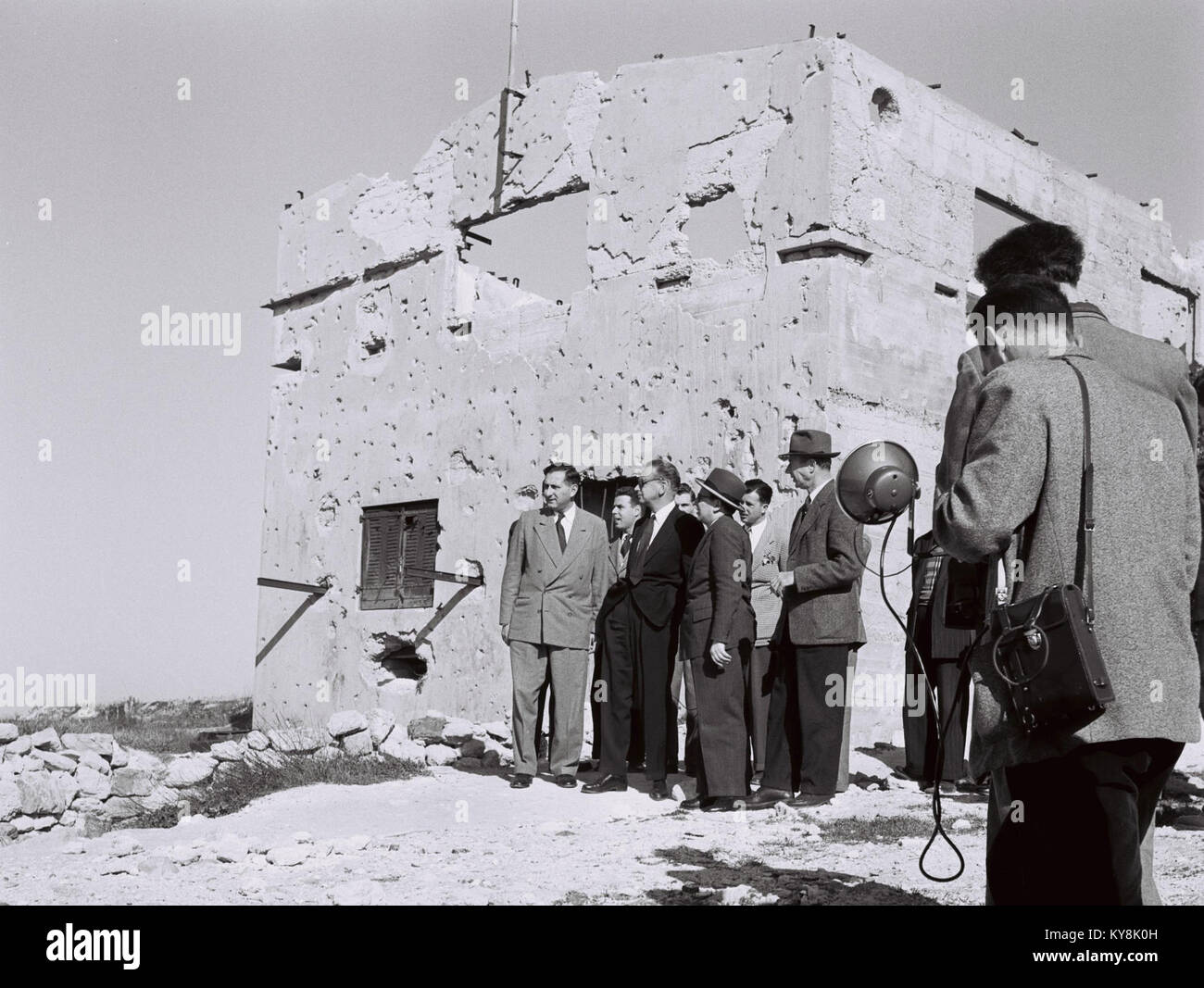 Dag Hammarskjöld und seine Partei besuchten ein Haus, das 1956 während der Suez-Krise im Kibbutz Ramat Rachel zerstört wurde, und dokumentierten Schäden nach dem Konflikt. Stockfoto