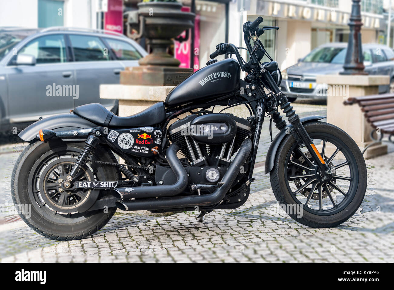 Harley Davidson Motorrad in mattem Schwarz auf einer gepflasterten Straße in Portugal geparkt. Stockfoto