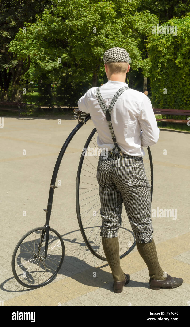 Junge Radfahrer in alten gekleidet, altmodische Kleidung steht mit seinem Fahrrad namens penny-farthing oder hohe Rad Stockfoto