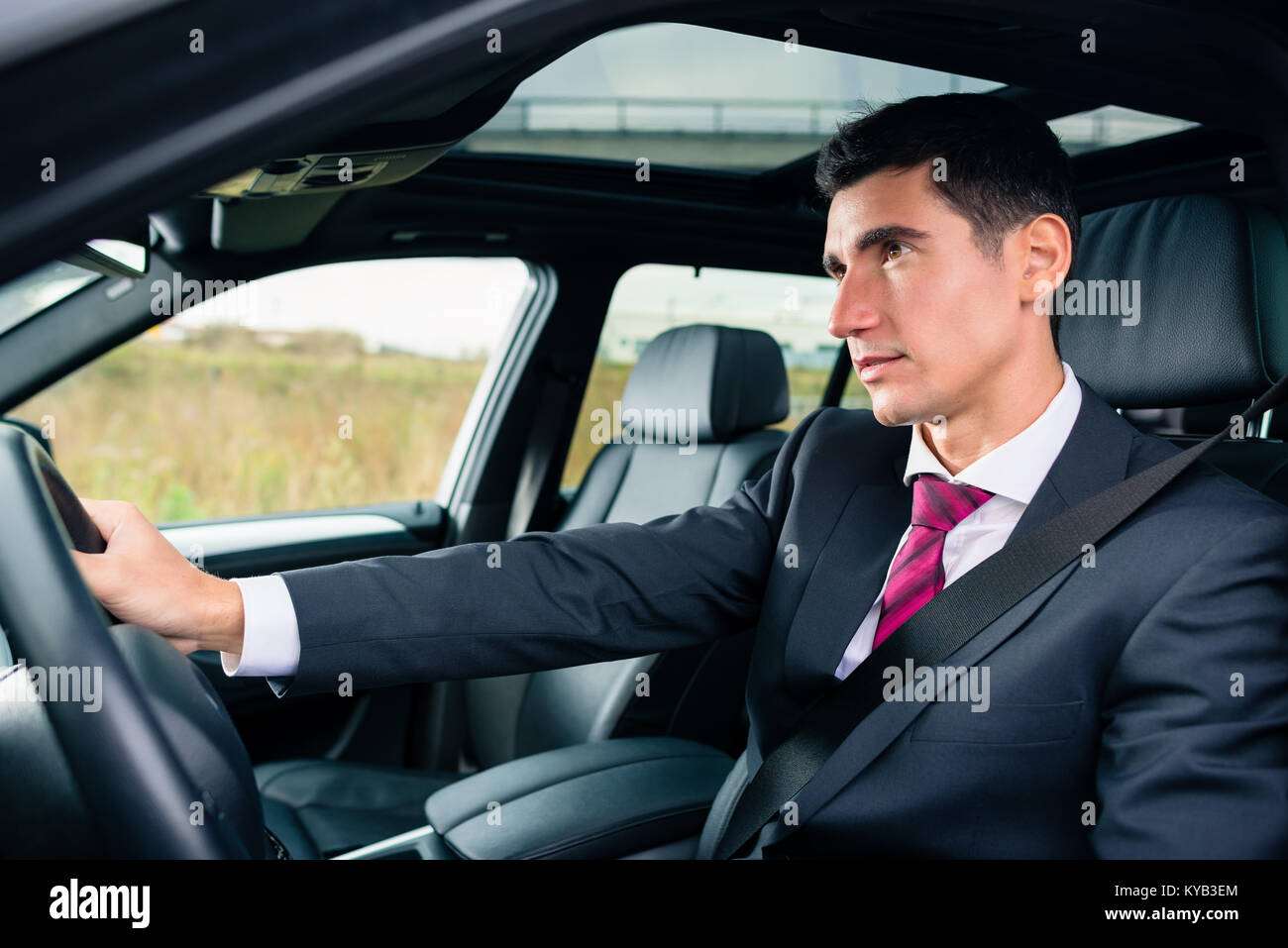 Mann, der in seinem Auto in Geschäftskleidung Stockfoto