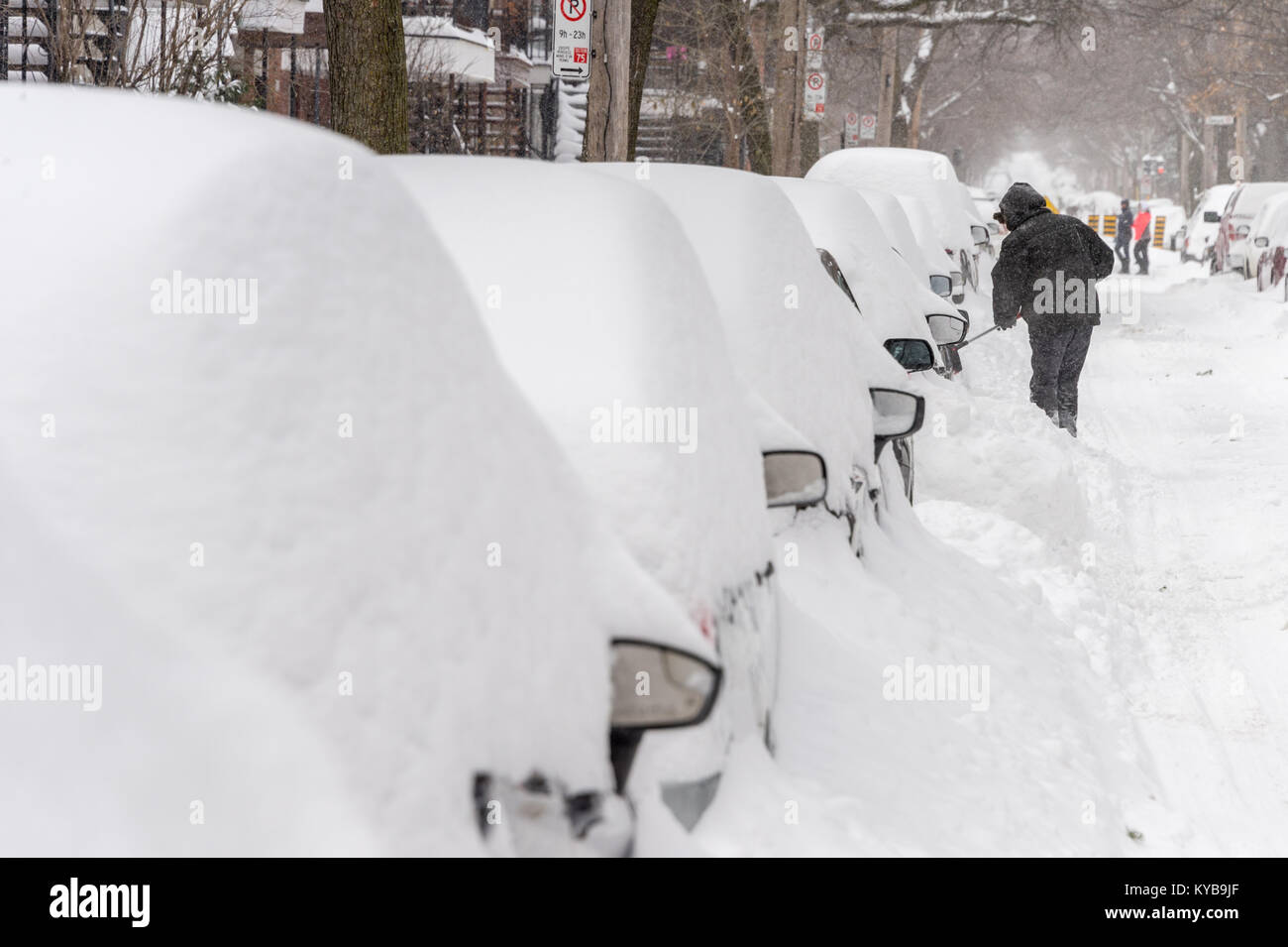 Montreal, Kanada - 13. Januar 2018: Ein Mann ist schneeschaufeln seine stecken Auto frei Stockfoto